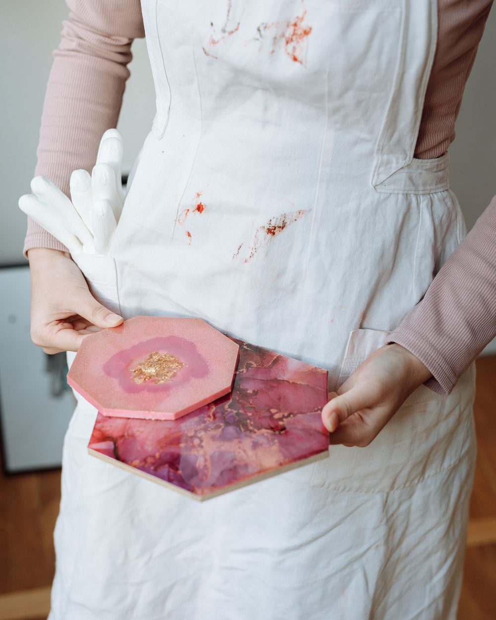 Pink resin hexagon coasters held in both hands